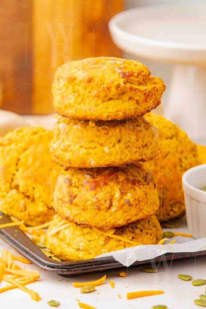 Straight-on hero shot of a tall stack of pumpkin cheddar scones